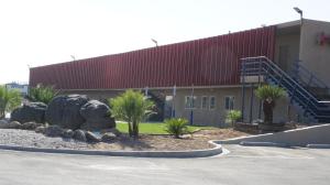 a building with a rock garden in front of a building at Apple Valley Hotel & Lodge in Apple Valley