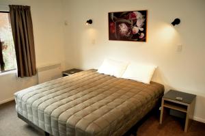 1 dormitorio con 1 cama y una foto en la pared en St James Apartments, en Queenstown