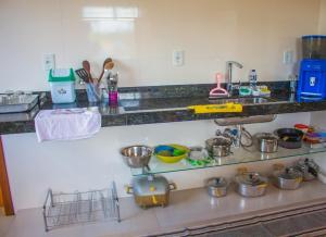 um balcão de cozinha com um lavatório e algumas panelas e frigideiras em Beco das Flores em Carrancas