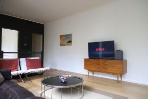 ein Wohnzimmer mit einem Sofa und einem TV auf einer Kommode in der Unterkunft The Walkup Southbank in Melbourne