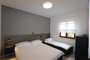 sypialnia z dwoma łóżkami i oknem w obiekcie Apartment in Silo with Two-Bedrooms 7 w mieście Šilo
