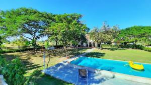 a backyard with a swimming pool and a yard with trees at Kampu Nature Pool Villa Rayong in Rayong