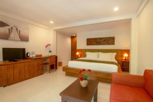a hotel room with a bed and a tv at Diva Lombok Resort in Senggigi