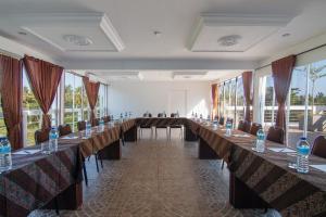 een grote kamer met lange tafels, stoelen en ramen bij Diva Lombok Resort in Senggigi  +37 foto's