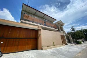 una casa con una porta in legno e un balcone. di RedDoorz near Mojokerto Train Station 