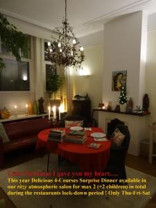 a living room with a red table and a chandelier at Boutiquehotel Sycamore - Protected City View - Free Parking in Eindhoven