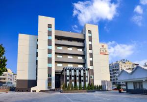 台南市にあるTalmud Hotel Tainanのたくさんの窓がある大きな白い建物