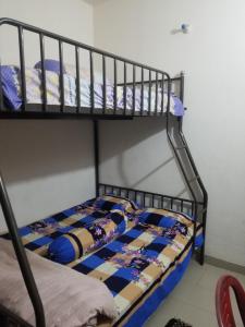 a bunk bed with a quilt on the bottom bunk at Short stay service apartment in Dhaka