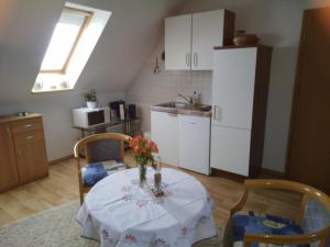 a kitchen with a table with a vase of flowers on it at Apartment Gingst 1 in Gingst