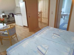 Zimmer mit einem Bett und einem Tisch sowie einer Küche in der Unterkunft Apartment Gingst 1 in Haidhof