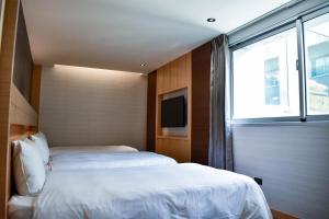 Postel nebo postele na pokoji v ubytování Talmud Hotel Tainan
