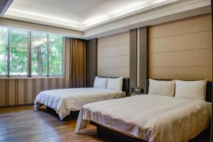 台南市にあるTalmud Hotel Tainanの窓が2つある部屋にベッドが2つある +37枚の写真