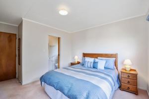 um quarto com uma cama com lençóis azuis e brancos em Blue Bach - Omori Holiday Home em Kuratau