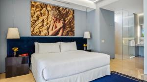 a bedroom with a white bed and a painting on the wall at PIER 57 - 211 Luxurious & Modern 1 BR Romantic Zone in Puerto Vallarta