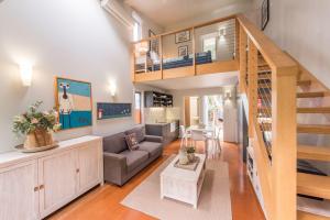 ein Wohnzimmer mit einem Sofa und einer Treppe in der Unterkunft Allure Stradbroke Resort in Point Lookout