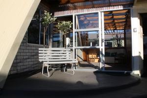 un banco blanco sentado fuera de un edificio en Classic A-frame on Milford en Te Anau