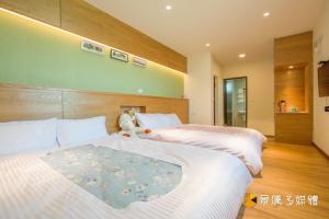 1 dormitorio con 2 camas y un osito de peluche entre ellas en Tong Xin Farmstay, en Gongguan
