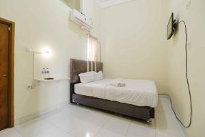 ein kleines Schlafzimmer mit einem Bett in einem Zimmer in der Unterkunft RedDoorz near OPI Mall Palembang 2 in Palembang