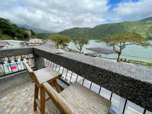 a bench sitting on a balcony overlooking a river at Lakeside 46 in Chinan