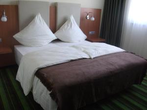 
Ein Bett oder Betten in einem Zimmer der Unterkunft Qualitel Hilpoltstein
