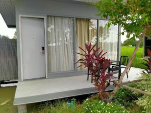 un porche de una casa con una puerta y una planta en wuadaeng villa en Ban Tabaeng