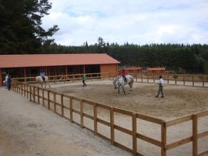 a group of people riding horses around a fence at Parque Biologico de Vinhais in Vinhais