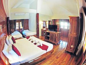 a bedroom with a large bed and a television at Chaipura Resort in Ko Chang