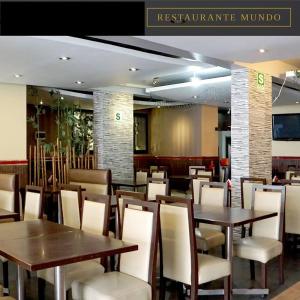 a restaurant with wooden tables and white chairs at Hotel Mundo in Lima