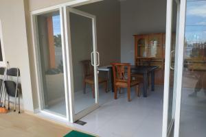 een eetkamer met glazen schuifdeuren en een tafel en stoelen bij Nietsa Guest House Syariah Palu Mitra RedDoorz in Palu