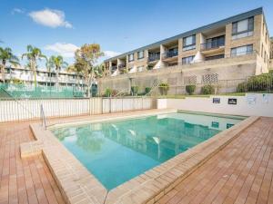 una piscina frente a un edificio en 14 The Dunes large unit with pool tennis court and directly across from Fingal beach, en Fingal Bay