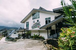 a white building with a sign on it at Amazing Grace Lodge in Kundasang