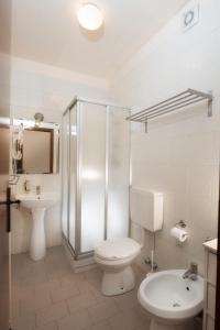 a white bathroom with a toilet and a sink at Hotel Rendez Vous in Châtillon