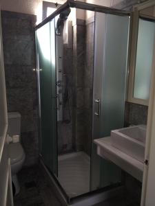 La salle de bains est pourvue d'une douche en verre et d'un lavabo. dans l'établissement Hotel Porto Loutro on the Hill, à Loutró