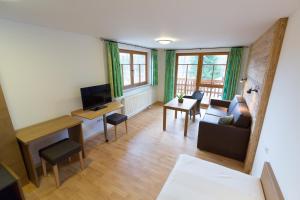 - un salon avec un canapé et une table dans l'établissement Hotel - Restaurant Forellenbach, à Fischen im Allgäu