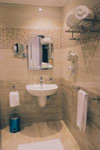 La salle de bains est pourvue d'un lavabo et d'un miroir. dans l'établissement Jewel Green Mountain Hotel, au Caire