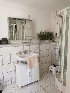 a white bathroom with a sink and a mirror at Ferienhaus Hase Bomsdorfer Hof in Gräfenhainichen