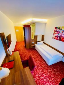 Hotel Günter في لينتيغ: غرفة فندق بسرير وسجادة حمراء