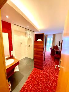 een badkamer met een douche, een wastafel en een spiegel bij Hotel Günter in Lenting