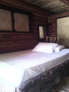a bed in a log cabin with two windows at Room in Lodge - Sierraverde Huasteca Potosina Cabins Palo De Rosa in Tamasopo