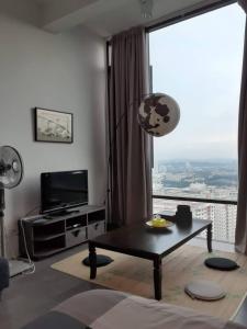 un soggiorno con tavolo e una grande finestra di Empire Damansara Homes by Cities Homes Malaysia a Petaling Jaya