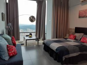 a bedroom with a bed and a couch and a window at Empire Damansara Homes by Cities Homes Malaysia in Petaling Jaya