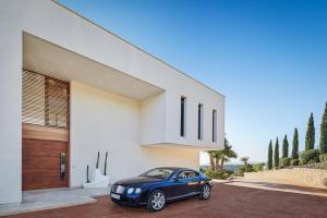 un coche azul estacionado frente a una casa en Eden Roc en Pòrtol