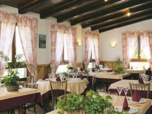 uma sala de jantar com mesas, cadeiras e janelas em Hotel du Mont Servy em Sainte-Enimie