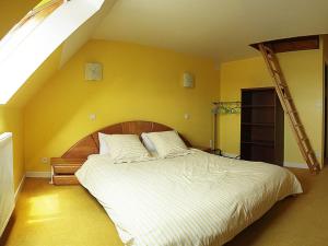 a bedroom with a large bed with a yellow wall at Les Chambres du Sillon in Pleubian