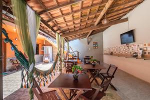 阿布拉昂的住宿－Hospedagem Cantinho Da Vitoria，餐厅设有木桌、椅子和电视。