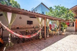 a patio with a hammock and a table and chairs at Hospedagem Cantinho Da Vitoria in Abraão