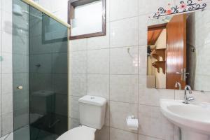 a bathroom with a toilet and a sink and a mirror at Hospedagem Cantinho Da Vitoria in Abraão +9 photos