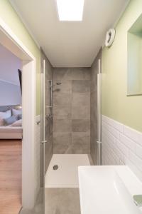 une salle de bain avec douche et lavabo dans l'établissement The Woodmans Airport Boardinghouse, à Düsseldorf