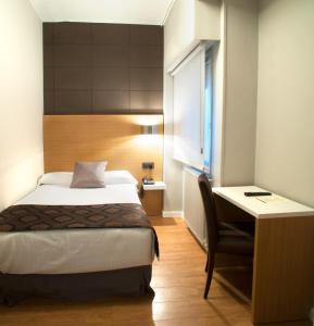 a bedroom with a bed and a desk at Hotel Universal in Santiago de Compostela