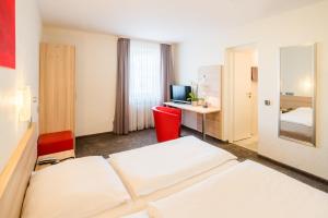 a hotel room with two beds and a television at Hotel Wanner in Böblingen